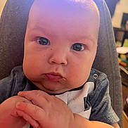 Bailey joined the competition — help win amazing prizes! baby, bodypart, clothing, cushion, eating, face, finger, food, frown, hand, hat, head, homedecor, mouth, newborn, person, photography, portrait, sad, sitting