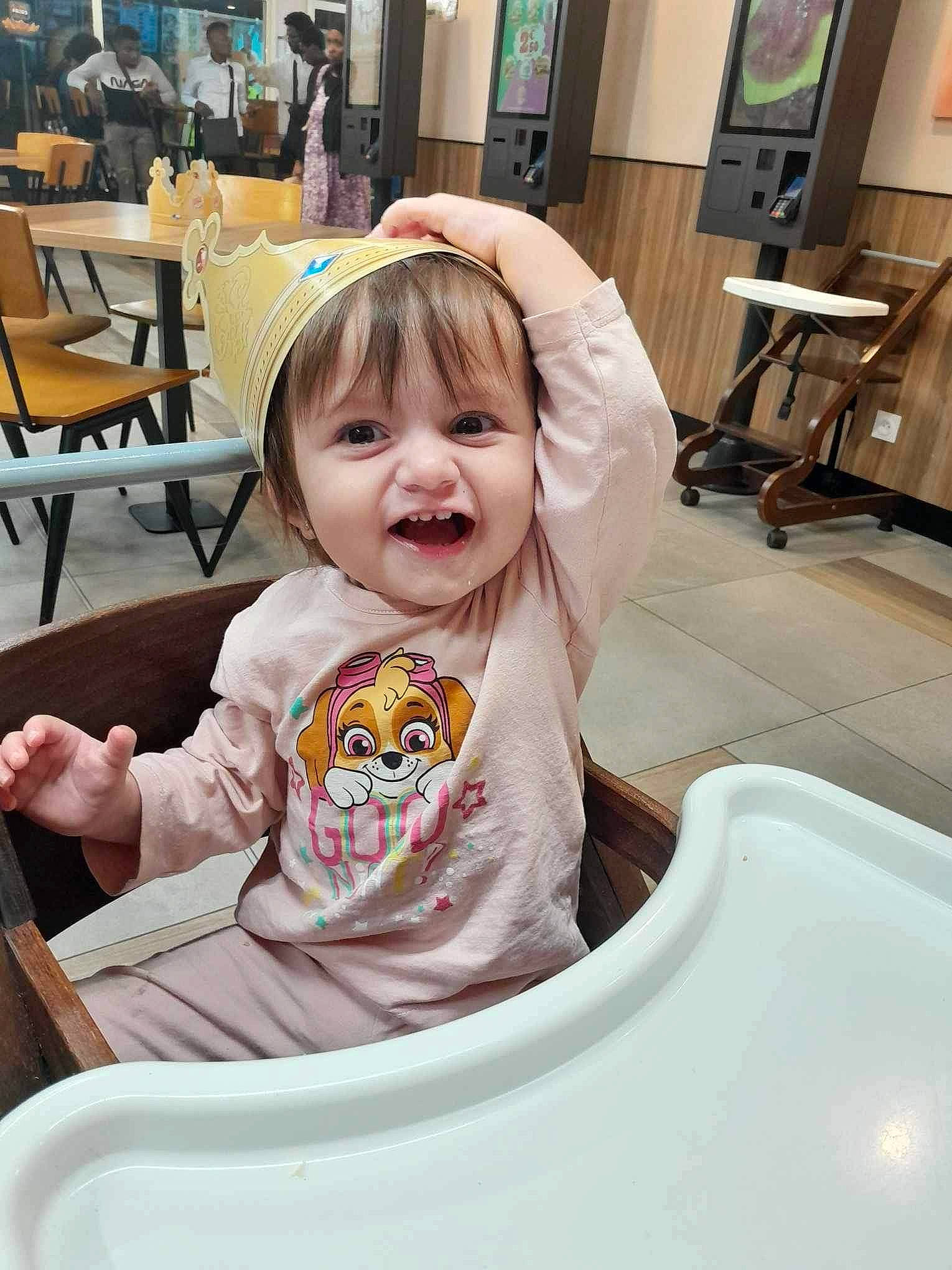 Eloise a rejoint le concours — aidez-le/la à gagner de superbes lots ! baby, baby_toddler_clothing, blond, chair, child, event, facial_expression, flooring, fun, furniture, hair, happy, leisure, person, sitting, sleeve, smile, t_shirt, table, toddler