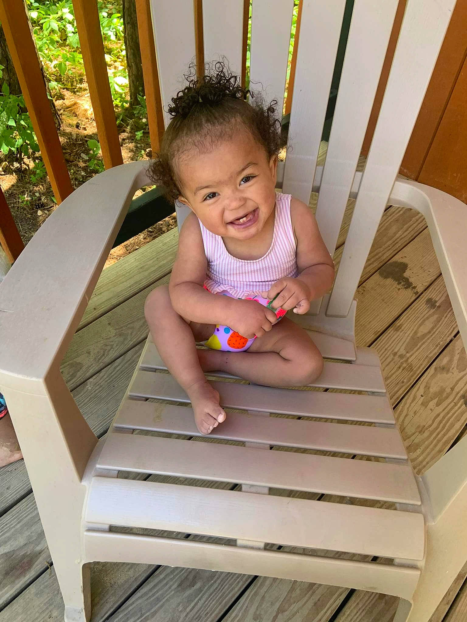 Kiana is registered to the contest to win money with this photo: baby_toddler_clothing, child, comfort, grass, green, happy, hardwood, house, leisure, outdoor_furniture, person, shorts, sitting, skin, smile, stairs, standing, t_shirt, toddler, wood
