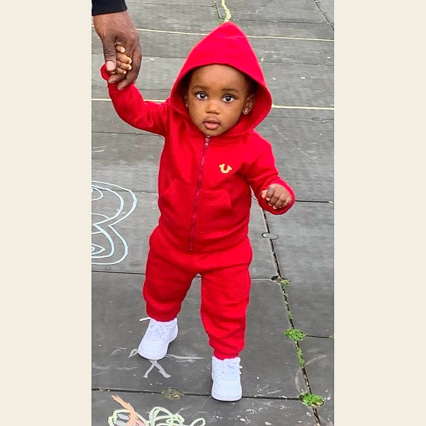 Regina is registered to the contest to win money with this photo: active_pants, arm, baby, baby_toddler_clothing, boot, cap, child, face, font, golf_equipment, happy, headwear, hood, human_body, magenta, outerwear, person, play, product, recreation