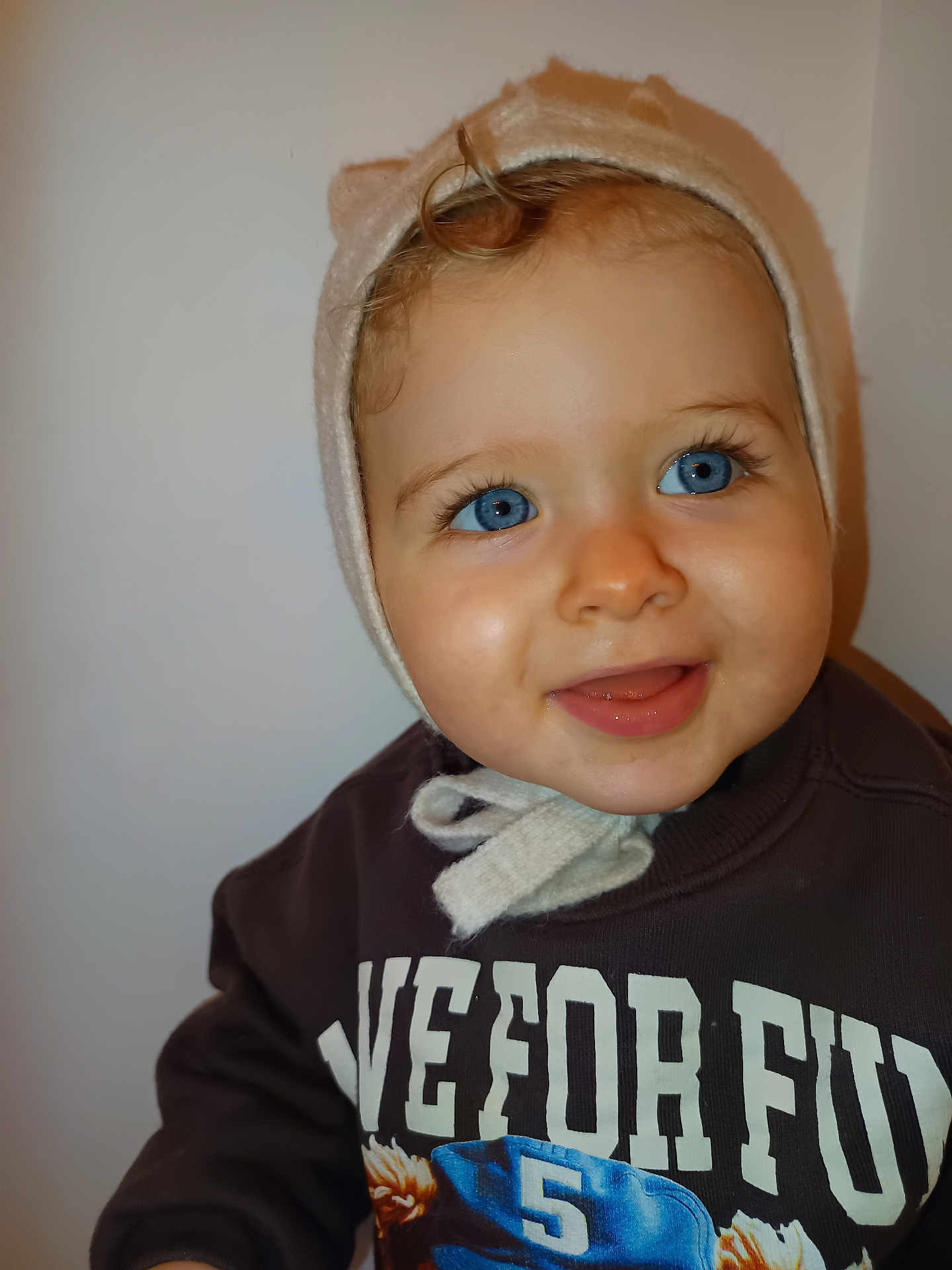 Diego participe au concours pour gagner de l'argent avec cette photo : toddler, child, blue_eyes, smile, hat, cozy_clothing, sweatshirt, portrait, face, happy, cute, indoor, closeup, baby, eyelashes, expression, person, headwear, warm_clothes, young_child