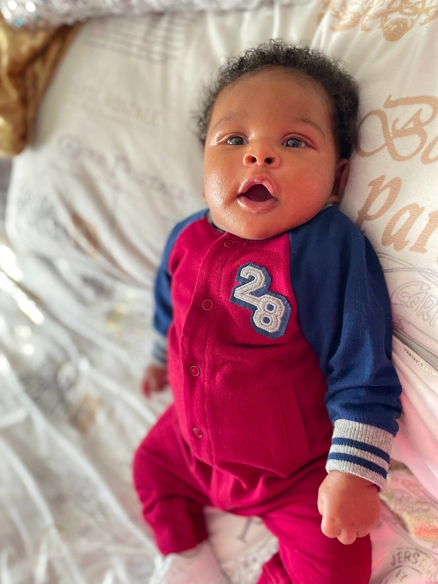 Azarias is registered to the contest to win money with this photo: baby, baby_toddler_clothing, cheek, collar, comfort, eye, face, happy, head, iris, linens, lip, neck, nose, outerwear, person, pink, skin, sleeve, textile