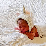 Lavaella joined the competition — help win amazing prizes! newborn, baby, sleeping, blanket, knitted_hat, unicorn, horn, pink_ears, white_bedspread, soft_texture, cozy, resting, infant, cute, portrait, indoors, peaceful, sleep, wrapped, child