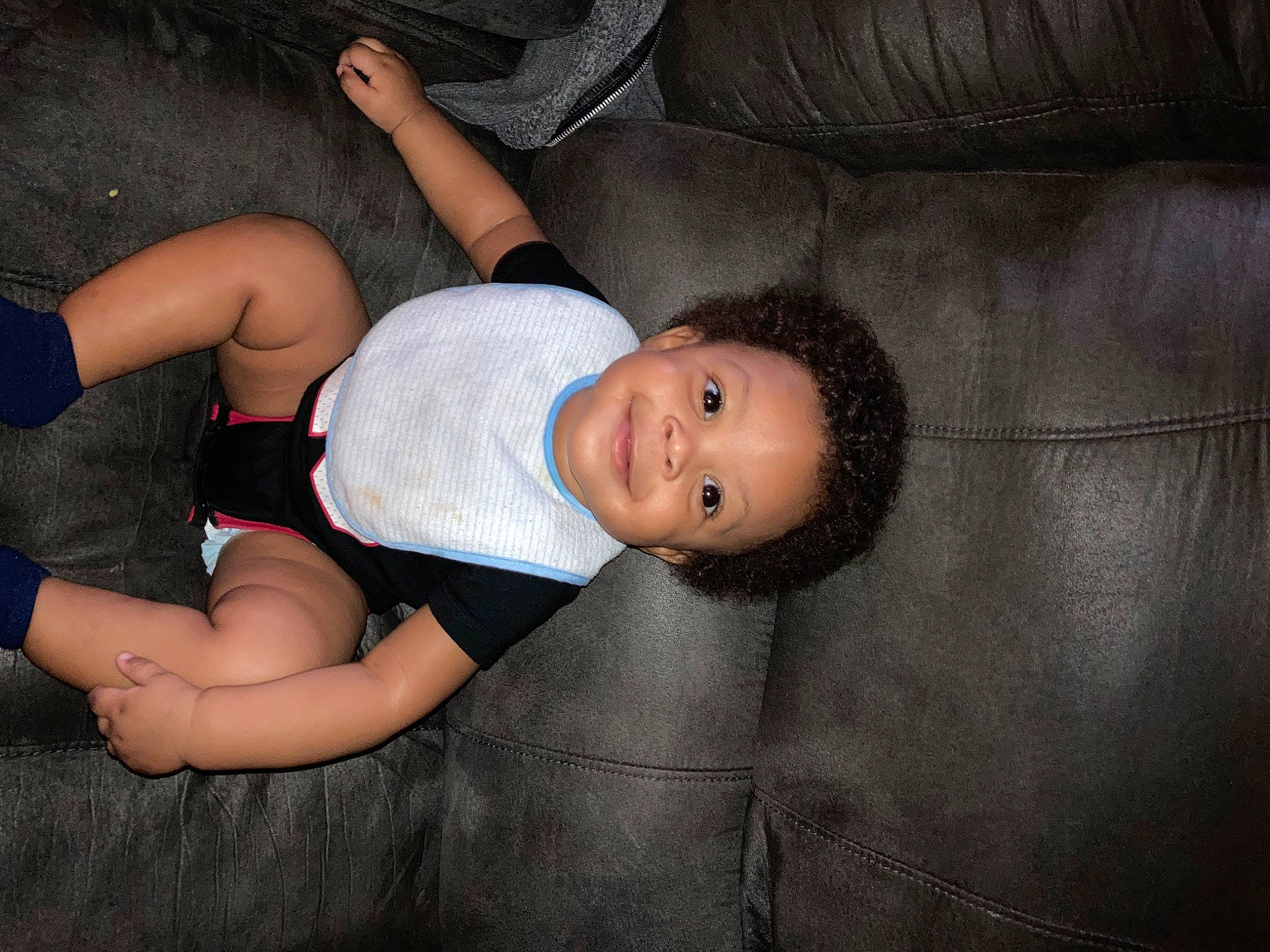 Antonio is registered to the contest to win money with this photo: abdomen, baby, baby_toddler_clothing, chest, child, comfort, elbow, eye, flash_photography, foot, human_leg, joy, knee, lap, person, shorts, sitting, smile, textile, thigh