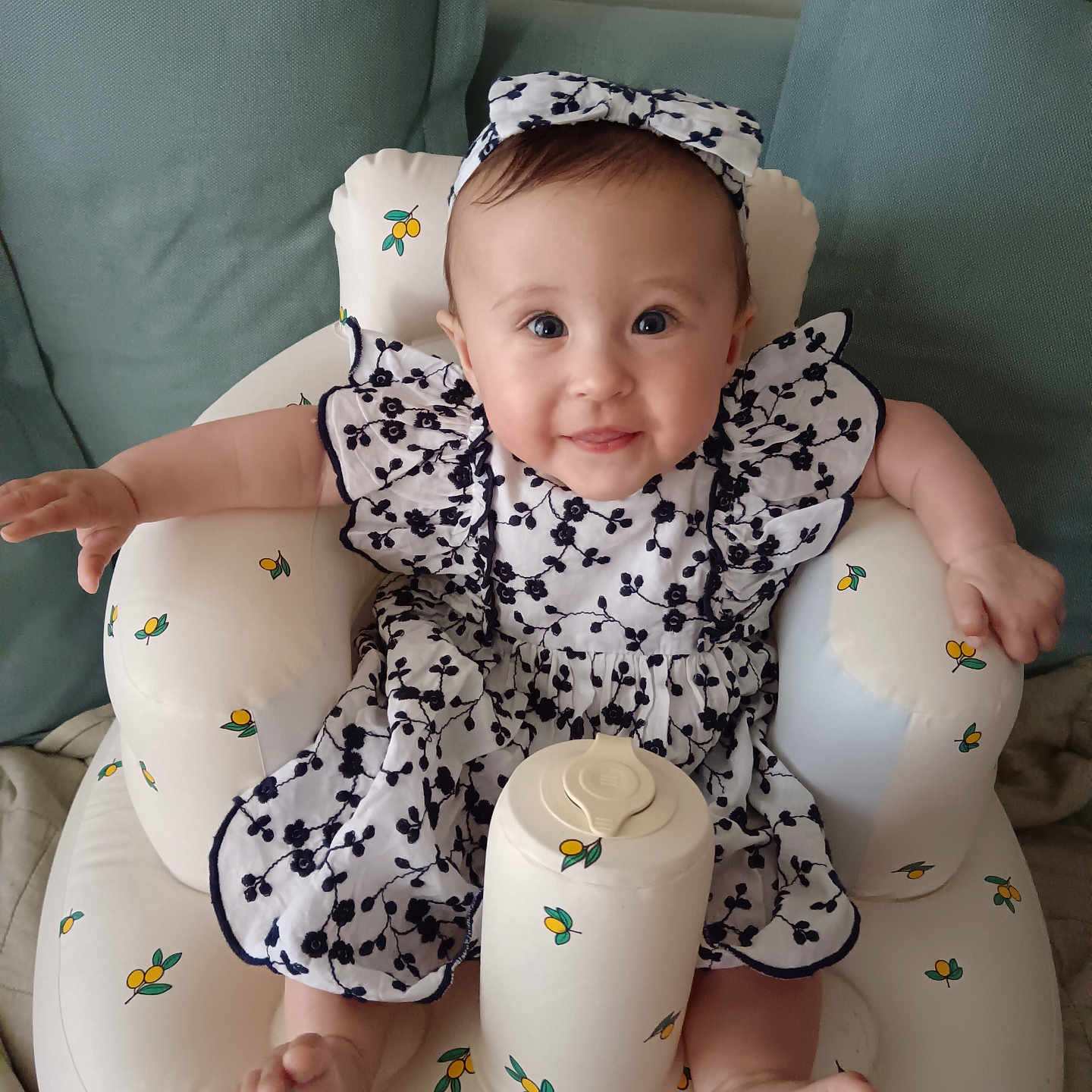 Imogen is registered to the contest to win money with this photo: baby, bodypart, bonnet, clothing, couch, cushion, dress, face, finger, furniture, hand, happy, hat, head, homedecor, person, photography, portrait, sitting, smile