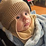 baby, child, hat, knit_hat, blanket, blue_blanket, cozy, infant, cute, portrait, indoors, warm_clothing, face, eyes, soft_texture, seated, closeup, person, young_child, winter_wear