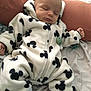 Mylann a rejoint le concours — aidez-le/la à gagner de superbes lots ! baby, sleeping, onesie, mickey_mouse_pattern, white_clothing, black_pattern, pillow, bed, blanket, cozy, infant, child, soft_fabric, cute, resting, hands, feet, socks, indoor, portrait