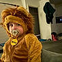 toddler, child, lion_costume, pacifier, indoor, living_room, couch, furry, cute, costume, baby, soft, plush, portrait, face, expression, home, clothing, seated, young