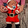 Thays a rejoint le concours — aidez-le/la à gagner de superbes lots ! baby, infant, santa_claus_outfit, pacifier, hands, adult, pink_sweater, blanket, bed, indoor, cute, holiday, christmas, red_clothing, black_boots, person, holding, soft_lighting, cozy, sleepwear