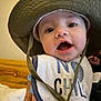 Maverick joined the competition — help win amazing prizes! baby, infant, hat, bib, face, mouth_open, expression, child, indoor, person, closeup, cute, smiling, headwear, fabric, skin, hand, bed, pillow, wood