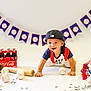 toddler, child, baseball, bat, glove, ball, crawling, cap, coca_cola, bottle, snack, banner, indoor, smiling, sports, toy, white_background, playing, celebration, festive