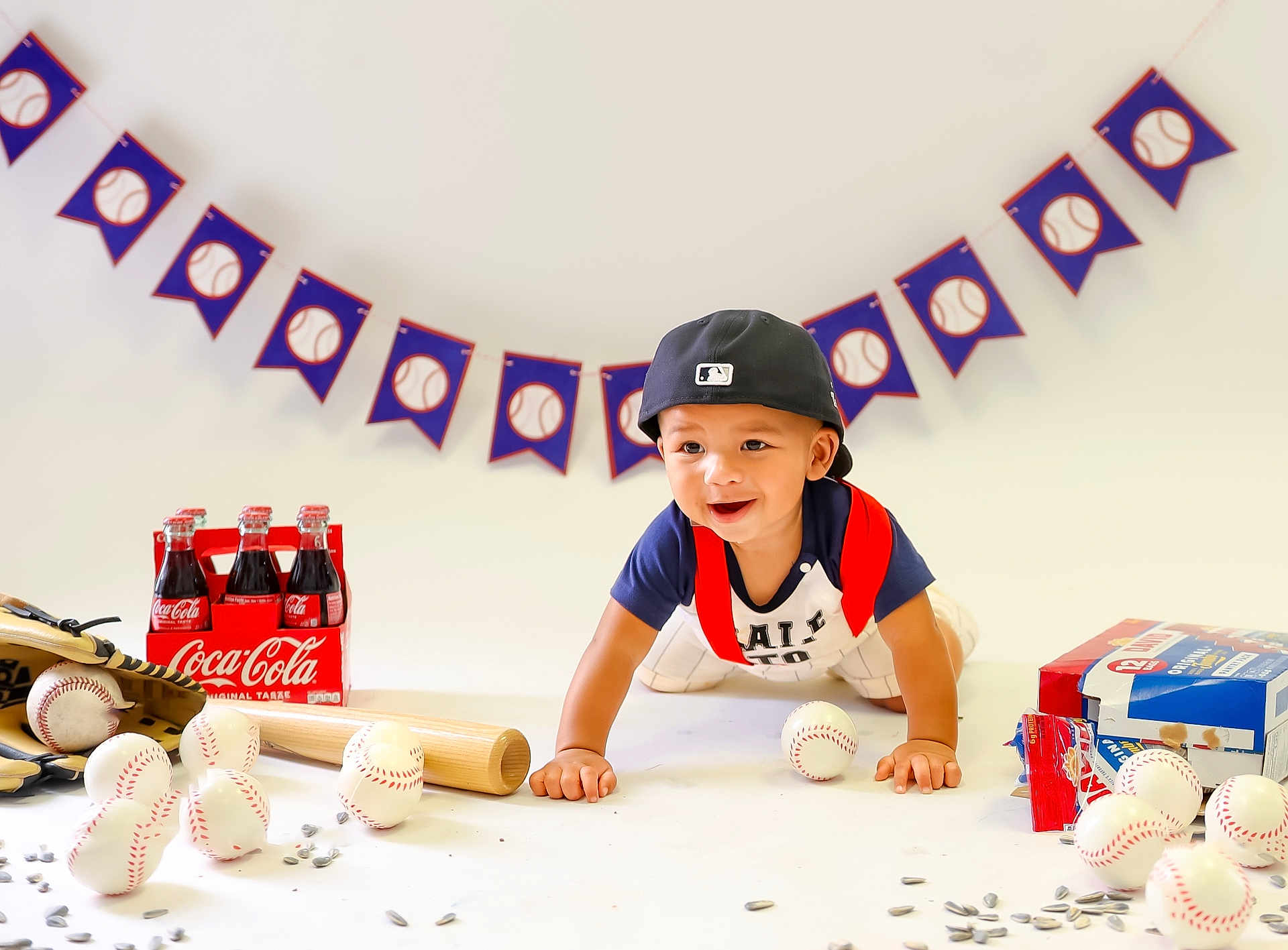 Theo joined the competition — help win amazing prizes! toddler, child, baseball, bat, glove, ball, crawling, cap, coca_cola, bottle, snack, banner, indoor, smiling, sports, toy, white_background, playing, celebration, festive