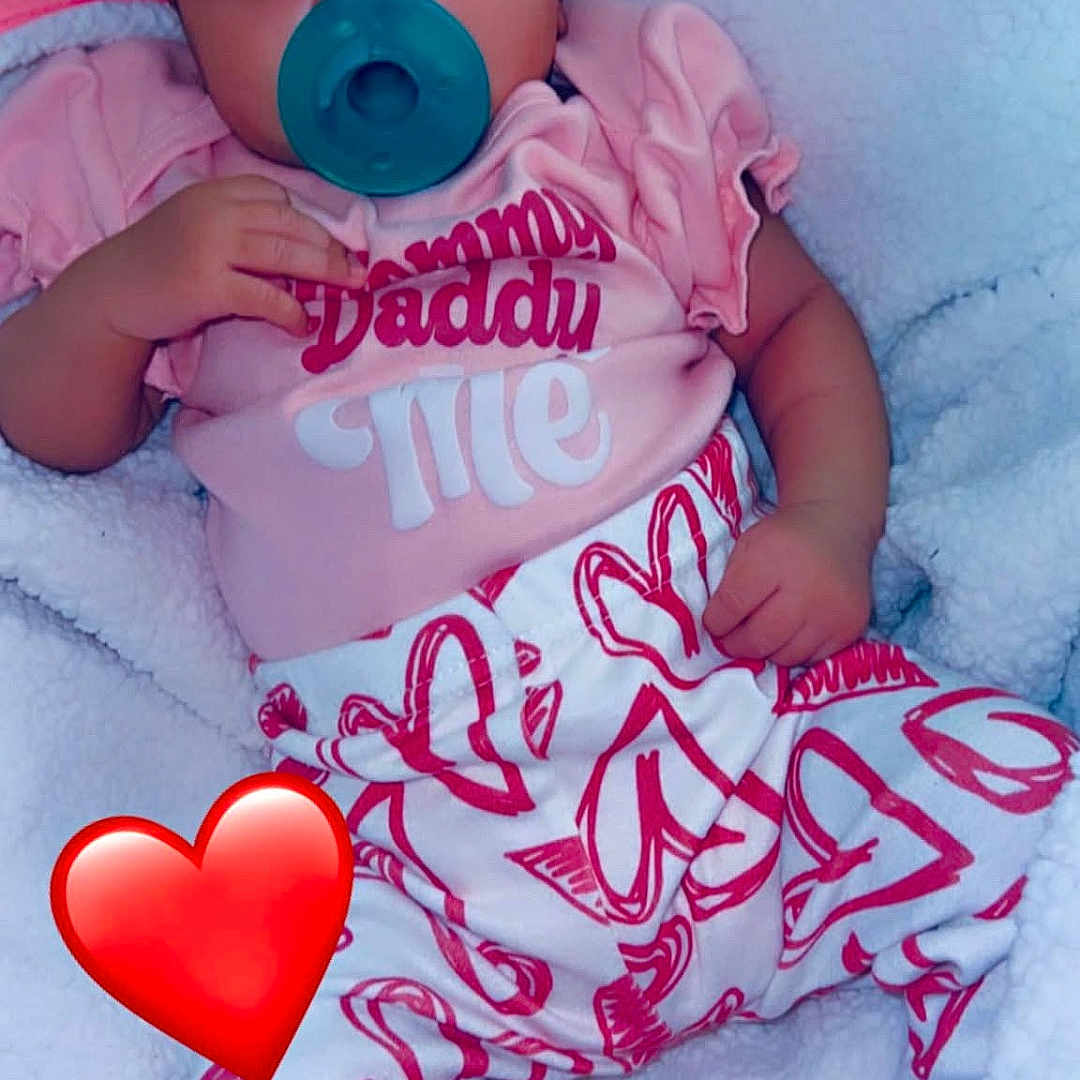 Ariyah is registered to the contest to win money with this photo: baby, pacifier, headband, pink_clothing, heart_pattern, blanket, infant, cute, sleepwear, child, soft_texture, relaxing, indoors, portrait, lying_down, cozy, adorable, small_hand, foot, red_heart_emoji