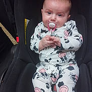 Lya a rejoint le concours — aidez-le/la à gagner de superbes lots ! baby, infant, car_seat, pacifier, onesie, cow_print, child, cute, sitting, indoor, clothing, person, seat, baby_clothes, holding, face, head, hands, comfort, young