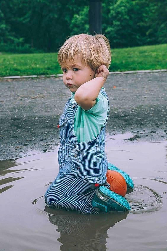 Hayden is registered to the contest to win money with this photo: bank, child, fun, green, outerwear, person, photography, play, pond, puddle, recreation, summer, toddler, vacation, water