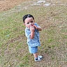 Steven is registered to the contest to win money with this photo: background, blue_car, car, casual_clothing, child, curious, daylight, expression, grass, nature, outdoor, park, person, playing, shirt, shoes, shorts, toddler, vehicle, young_child