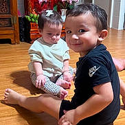 Axel joined the competition — help win amazing prizes! child, baby, toddler, floor, wooden_floor, smile, sitting, indoor, shrine, buddha_statue, flower, decor, curly_hair, clothing, person, happy, cute, home, furniture, playful