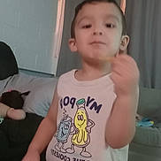 Axel joined the competition — help win amazing prizes! child, indoor, shirt, cartoon, snack, hand, face, curtains, couch, person, young, sleeveless_shirt, popcorn, soda_can, furniture, living_room, casual, smiling, standing, food