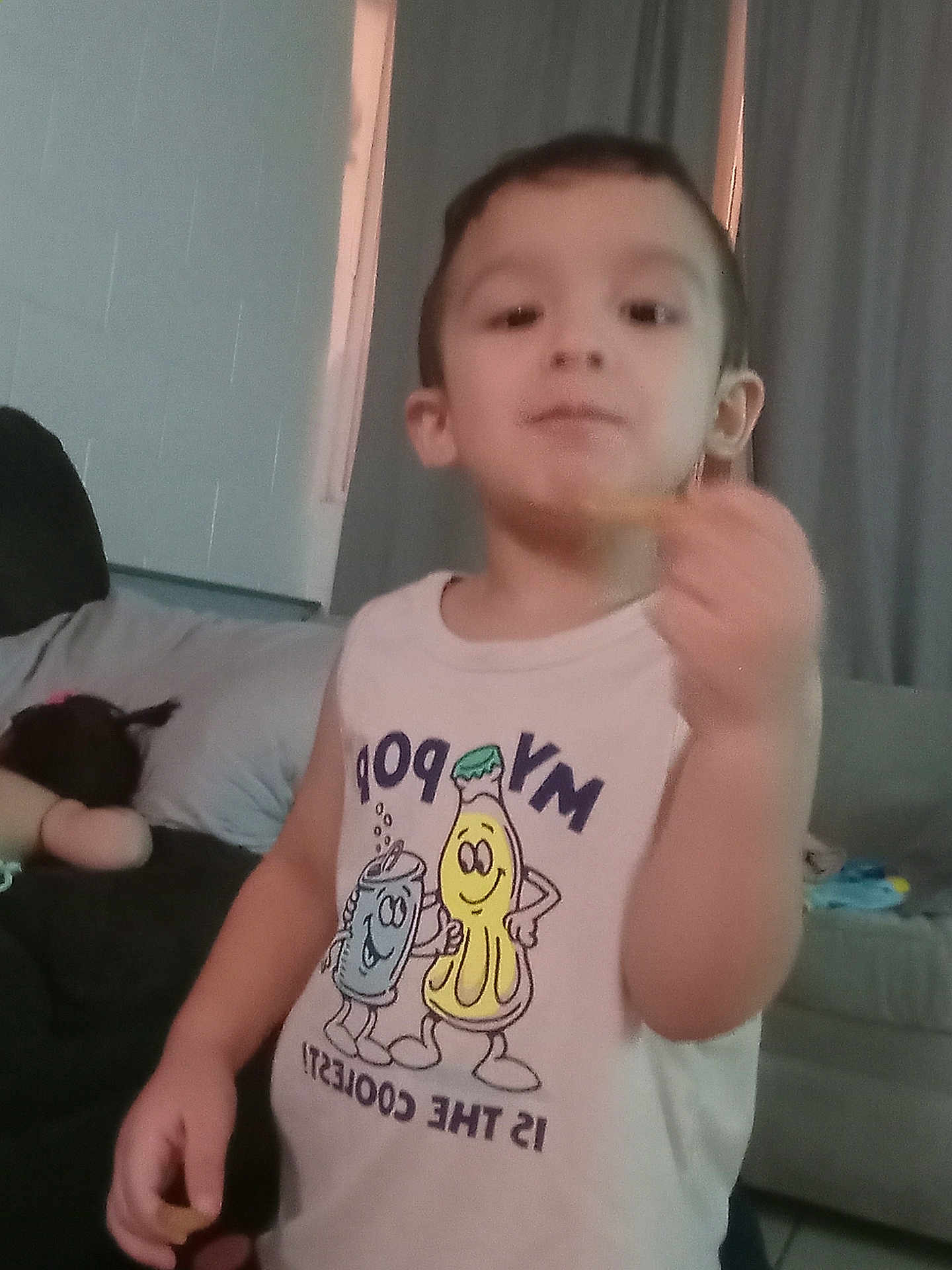 Axel joined the competition — help win amazing prizes! child, indoor, shirt, cartoon, snack, hand, face, curtains, couch, person, young, sleeveless_shirt, popcorn, soda_can, furniture, living_room, casual, smiling, standing, food