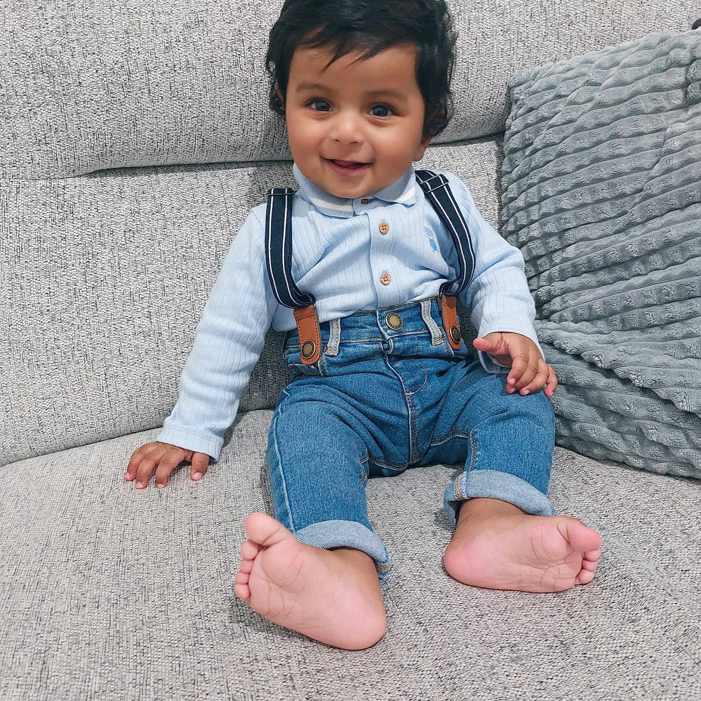 Yusuf joined the competition — help win amazing prizes! baby, barefoot, child, comfortable, couch, cute, denim_jeans, fabric, hair, happy, home, indoors, light_blue_shirt, plush_pillow, portrait, sitting, skin, smiling, suspenders, toddler