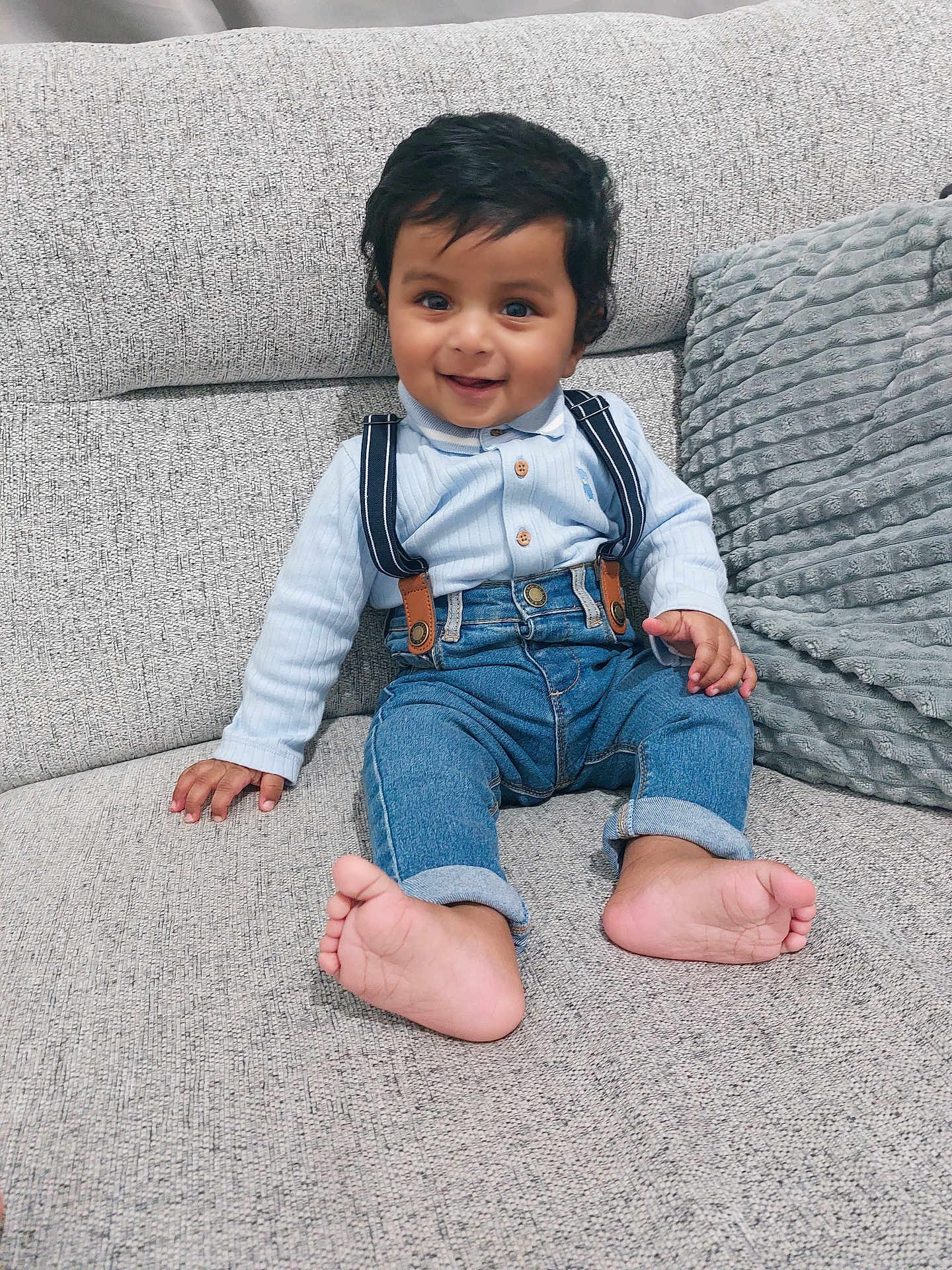 Yusuf joined the competition — help win amazing prizes! baby, child, smiling, sitting, couch, denim_jeans, suspenders, light_blue_shirt, barefoot, indoors, happy, cute, portrait, toddler, fabric, home, comfortable, plush_pillow, skin, hair