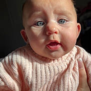 Athena joined the competition — help win amazing prizes! baby, child, face, blue_eyes, sweater, knitwear, hand, skin, cute, indoor, portrait, expression, fingernails, person, infant, young_child, warm_clothing, closeup, soft_light, curious