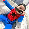 Fernando joined the competition — help win amazing prizes! toddler, child, baby, costume, spiderman, sunglasses, blue, red, playful, cute, indoors, cushion, baby_lounger, animal_print, person, smiling, hand, seat, clothing, portrait