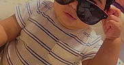 Fernando joined the competition — help win amazing prizes! toddler, child, sunglasses, striped_shirt, indoor, cushion, animal_print, baby, cute, portrait, home, furniture, seat, person, relaxing, fashion, cool, comfort, clothing, infant