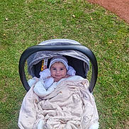 Dervis a rejoint le concours — aidez-le/la à gagner de superbes lots ! baby, blanket, baby_carrier, grass, outdoor, smiling, face, headwear, cozy, cute, person, child, infant, nature, soft, warm, happy, portrait, seat, fabric