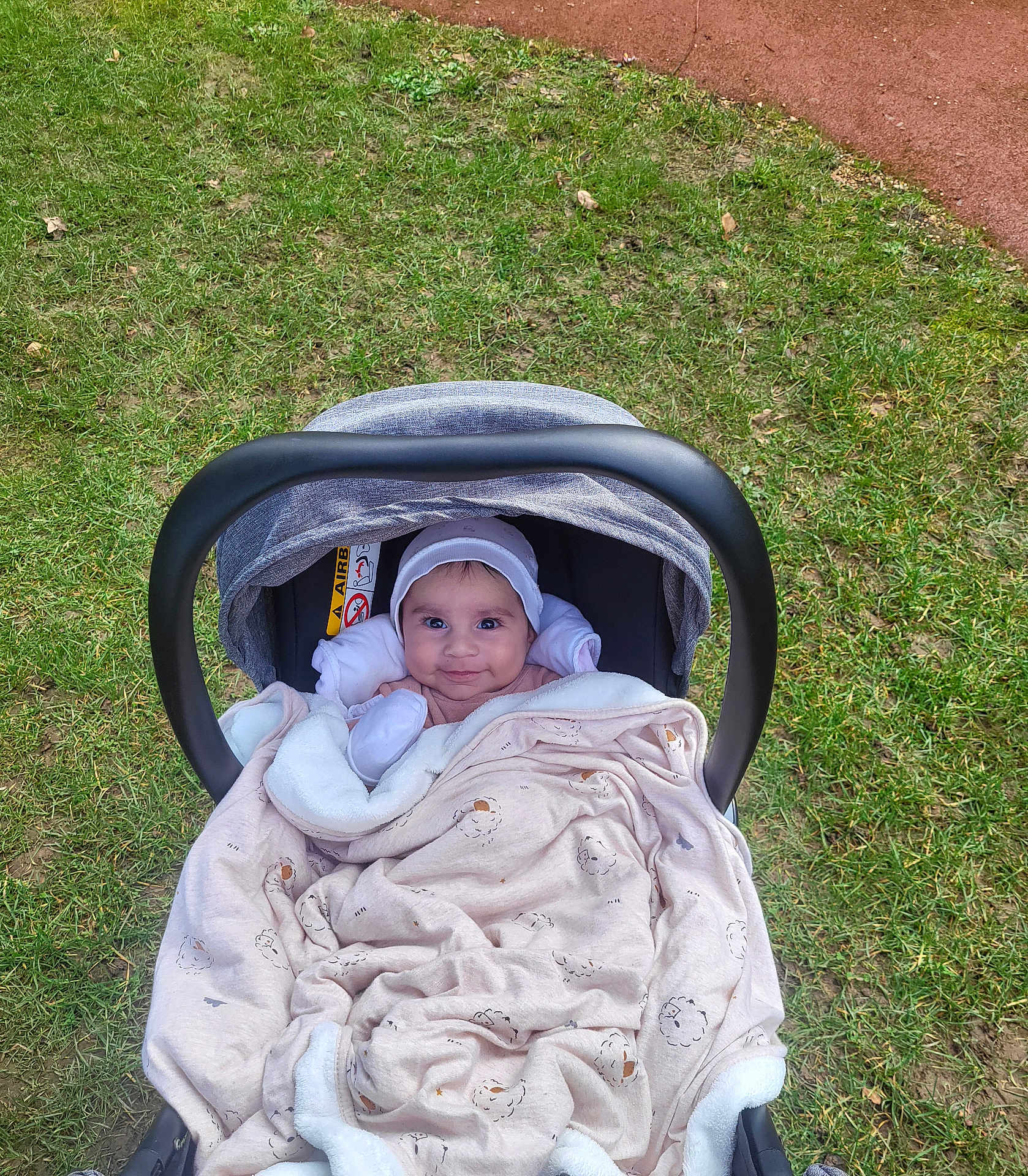 Dervis a rejoint le concours — aidez-le/la à gagner de superbes lots ! baby, blanket, baby_carrier, grass, outdoor, smiling, face, headwear, cozy, cute, person, child, infant, nature, soft, warm, happy, portrait, seat, fabric