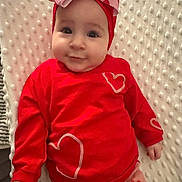 Lilianna is registered to the contest to win money with this photo: baby, infant, red_clothing, headband, bow, heart_pattern, blanket, cute, child, smiling, lying_down, soft_texture, indoors, portrait, closeup, adorable, warm_colors, baby_fashion, toddler, happy