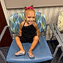 Jazmynn joined the competition — help win amazing prizes! child, girl, smiling, waiting_room, chair, patterned_chair, sparkly_shoes, shoes, pink_bow, hair_bows, black_outfit, armrest, backpack, carpet, hospital, portrait, candid, happy, feet, wall_paneling