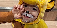 Aedhan Herrbach a rejoint le concours — aidez-le/la à gagner de superbes lots ! child, costume, face_paint, yellow, lion, playful, smile, hand, stairs, wood, brown_clothing, hood, ears, cute, indoor, portrait, fun, expression, animal_costume, young