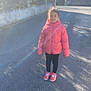 Raissa a rejoint le concours — aidez-le/la à gagner de superbes lots ! asphalt, blurred_background, casual_clothing, child, cold_weather, daytime, fence, hooded_jacket, outdoor, person, pink_jacket, shadow, shoes, sidewalk, standing, street, sunlight, trees, urban, young