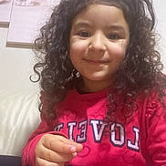 Raissa a rejoint le concours — aidez-le/la à gagner de superbes lots ! child, clothing, couch, cozy, curly_hair, eyes, face, girl, hair, hand, happy, heart_pattern, home_decor, indoor, pink_sweater, portrait, sitting, smile, sofa, wall_art