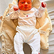 Emilio a rejoint le concours — aidez-le/la à gagner de superbes lots ! newborn, baby, infant, blanket, white_clothing, red_heart, lying_down, soft_texture, cute, sleepwear, cozy, small_hands, face, head, person, indoors, bed, resting, child, peaceful