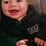 Aaron is registered to the contest to win money with this photo: baby, smile, happy, face, child, hoodie, button, hand, infant, portrait, cute, young, skin, eyes, expression, clothing, comfort, indoors, sitting, joy