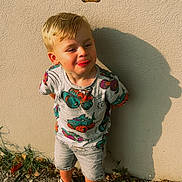 Mylann a rejoint le concours — aidez-le/la à gagner de superbes lots ! boy, cartoon, child, cute, emotion, grass, ground, outdoor, playful, shadow, shirt, shorts, standing, stick, sunlight, texture, tongue_out, vehicles, wall, white_shoes