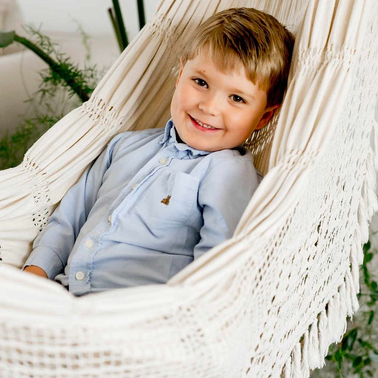 Mathias is registered to the contest to win money with this photo: boy, child, clothing, face, furniture, hammock, happy, head, herbal, herbs, laughing, male, pants, person, photography, plant, portrait, shirt, sitting, smile