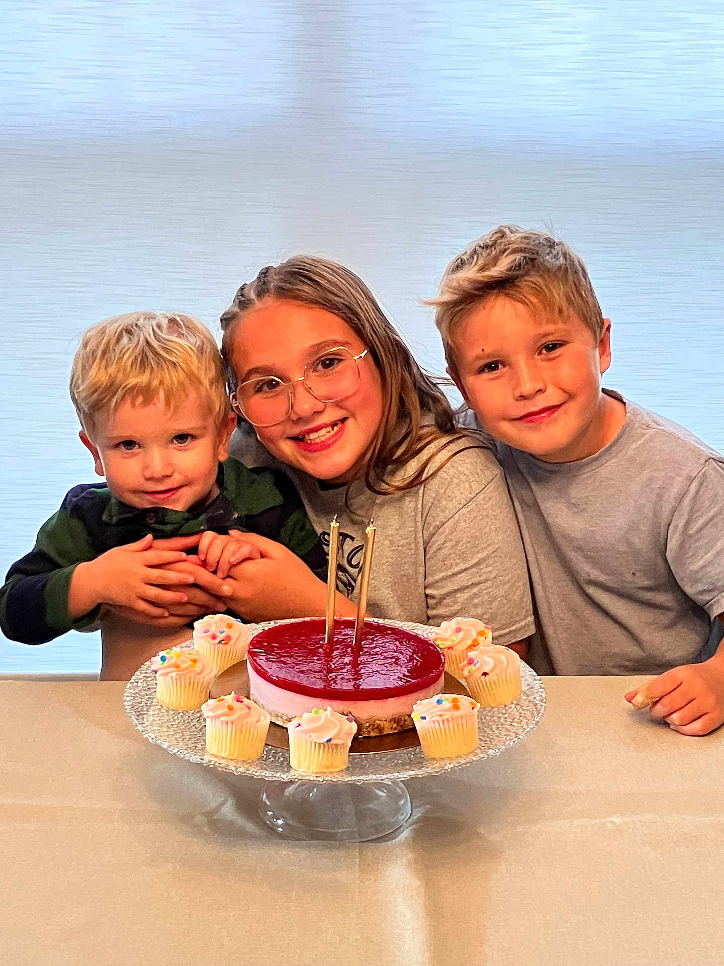 Samuel a rejoint le concours — aidez-le/la à gagner de superbes lots ! children, smiling, birthday_cake, cupcakes, table, glasses, portrait, family, siblings, indoor, happy, hands, blond_hair, gray_shirt, green_shirt, dessert, candles, cake_stand, celebration, center_composition
