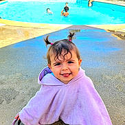 Ombelyne a rejoint le concours — aidez-le/la à gagner de superbes lots ! toddler, child, poolside, swimming_pool, towel, pigtails, playful, tongue_out, outdoor, sunny, water, people, summer, fun, happy, cute, daylight, recreation, family, vacation