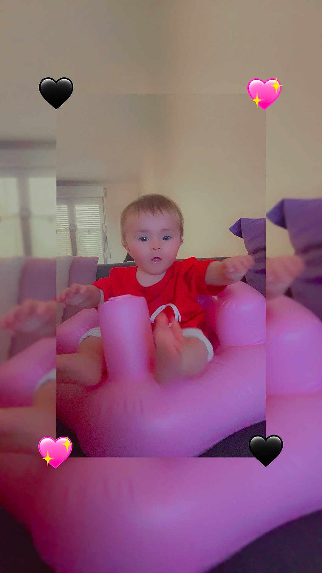 Keyla participe au concours pour gagner de l'argent avec cette photo : toddler, child, inflatable_chair, pink, red_shirt, indoor, couch, cushions, curious, baby, furniture, home, person, expression, heart_emoji, cute, seated, soft_light, living_room, portrait