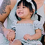 Jade joined the competition — help win amazing prizes! toddler, child, smiling, bow_headband, dress, tattoo, adult, holding_hands, sitting, happy, portrait, person, skin, arm, hand, foot, black_hair, indoors, close_up, family