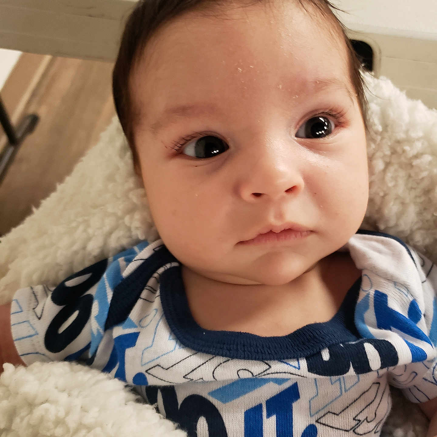 Liam joined the competition — help win amazing prizes! baby, blanket, child, closeup, clothing, cute, expression, eyes, face, head, indoor, infant, newborn, onesie, person, portrait, skin, soft, warm, young