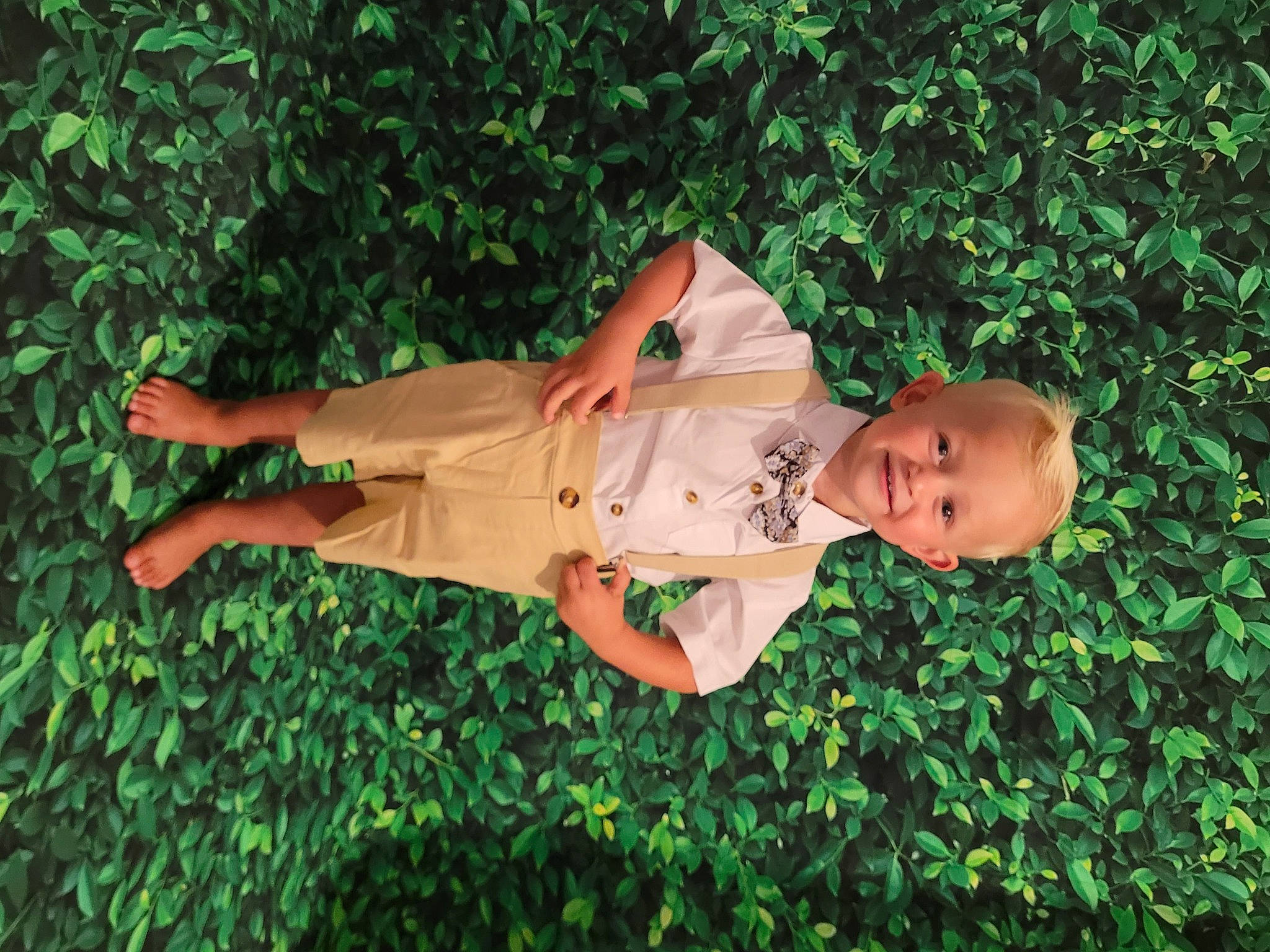 Mylann participe au concours pour gagner de l'argent avec cette photo : baby_toddler_clothing, child, fun, garden, grass, groundcover, happy, hat, joy, leisure, people_in_nature, person, plant, shorts, shrub, thumb, toddler, wood, wrist