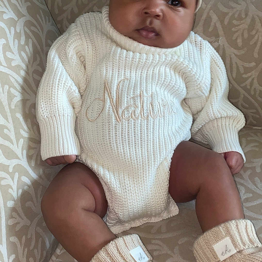 Nature is registered to the contest to win money with this photo: armchair, baby, booties, bow, child, clothing, comfortable, cozy, cute, fashion, headband, indoors, infant, knitwear, patterned_fabric, portrait, sitting, soft_texture, warm, young_child