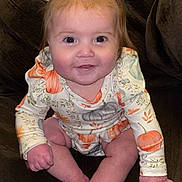 Zora joined the competition — help win amazing prizes! baby, child, pigtails, bows, pumpkin, long_sleeve, smile, face, hands, feet, couch, brown_couch, clothing, infant, cute, indoors, portrait, sitting, happy, person