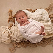 Isaö a rejoint le concours — aidez-le/la à gagner de superbes lots ! baby, infant, wrapped, white_cloth, basket, blanket, lace, knitted, soft_texture, cozy, portrait, newborn, feet, hands, curious_expression, indoor, neutral_background, resting, cute, child