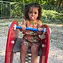 Léyna a rejoint le concours — aidez-le/la à gagner de superbes lots ! toddler, child, pacifier, playground, spring_rider, outdoor, gravel, fence, greenery, curly_hair, sandal, colorful_clothing, toy, summer, nature, daylight, young_child, sitting, play, park