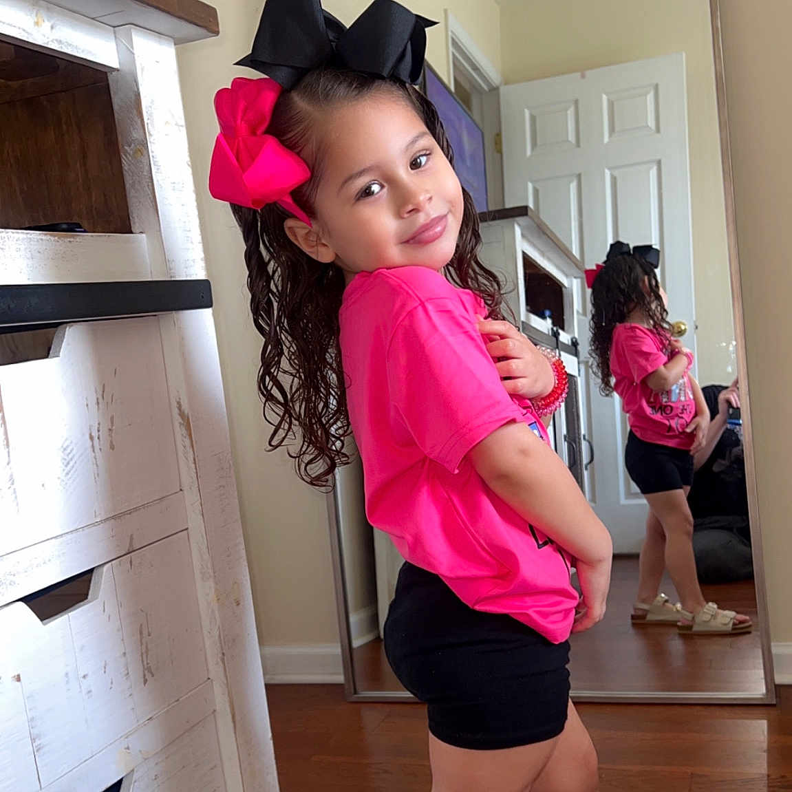 Isabella is registered to the contest to win money with this photo: cabinet, child, closet, clothing, cupboard, dress, face, female, footwear, furniture, girl, hardwood, hat, head, person, photography, sandal, shoe, shorts, wood